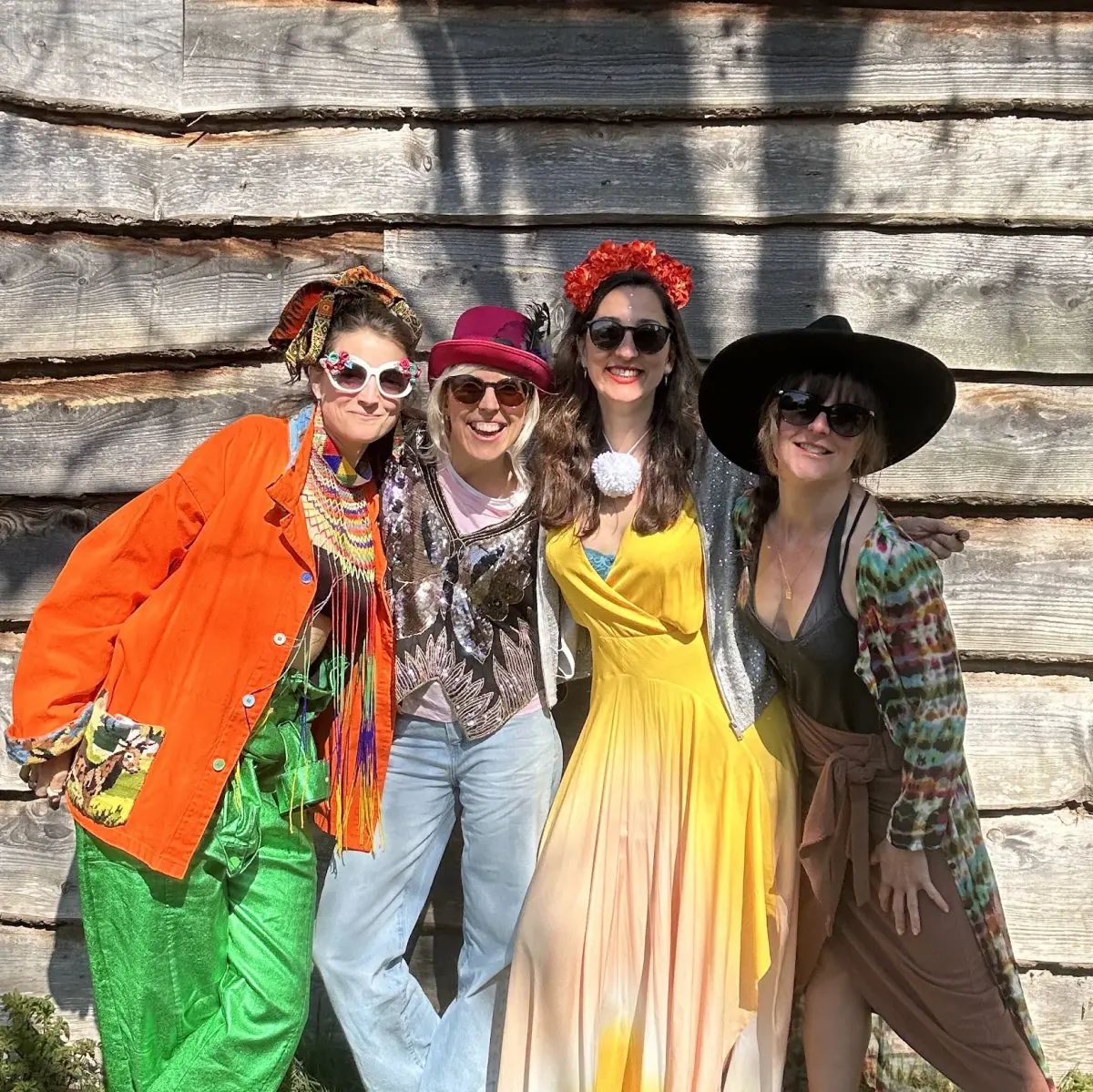 Four colivers dressed up against the barn wall in the sun